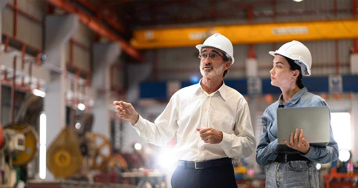 Two people on a tour of a commercial or industrial property, discussing submetering electricity and gas